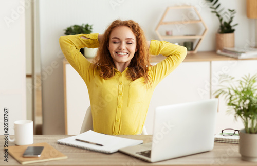 Happy creative designer stretching, working in office