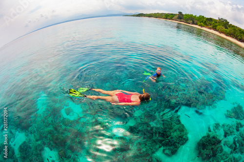 Happy family - mother, kid in snorkeling mask dive underwater, explore tropical fishes in coral reef sea pool. Travel active lifestyle, beach adventure, swimming activity on summer holiday with child.