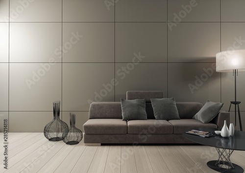 Minimalistyczne wnętrze z sofą, stolikiem i wazonami na tle ściany z szarymi panelami.