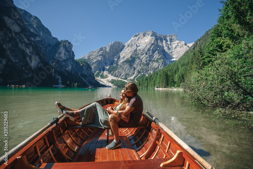 Coupl in love on the boat or canoe cruise tour on lago Di Braies lake in Italian Dolomites Alps