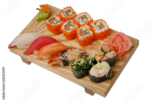 Sushi on a wooden stand, wasabi and pickled ginger. On white isolated background