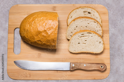 Chleb na desce do krojenia. Pół bochenka chleba i trzy kromki. Przygotowywanie kanapek.