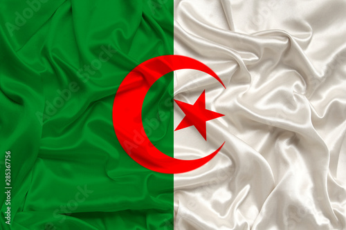 National flag of the country algeria on gentle silk with wind folds, travel concept, immigration, politics