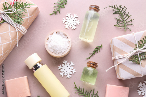 Christmas gift boxes and products for spa treatment on color background