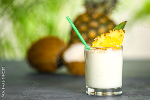 Glass of tasty Pina Colada cocktail on table