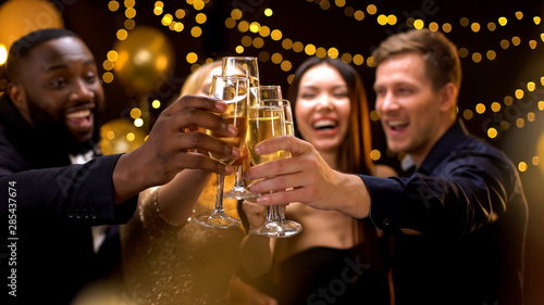 Cheerful multi-racial friends clinking champagne glasses, corporate event, fun