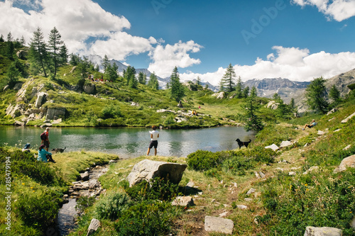 Mountain lake landscape with people near Bellagarda lake. Sense of freedom. Gran Paradiso National Park, Ceresole Reale, Piedmont, Italy