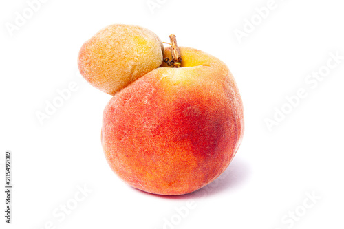 Trendy ugly food concept. Peach fruit isolated on white background. Misshapen produce, food waste problem