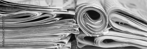 A stack of folded newspapers on the desktop in the office. Latest financial and business news in daily paper.