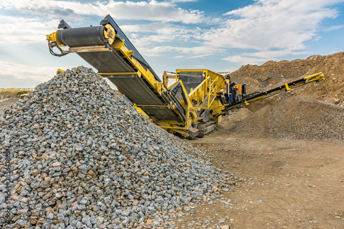 Stone crusher machine in a quarry or open-pit mine, to transform into gravel