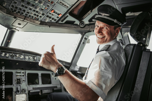 Smiling pilot in cockpit looking at camera