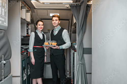 Smiling flight attendant with pilot posing for camera