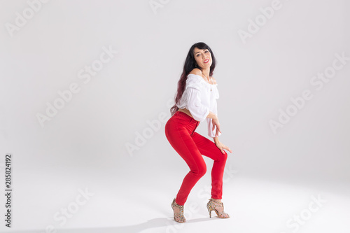 Latin dance, contemporary dance, bachata solo and cha-cha-cha concept - portrait of a young woman salsa dancer in a dance pose on white background with copy space