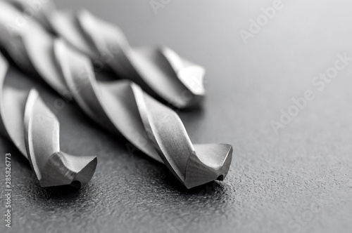 Drill bits on black background. Space for text.