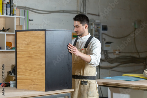Furniture factory and small and medium sized enterprises concept - Man collects furniture details