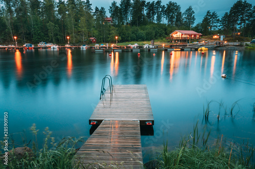 Sweden. Beautiful Wooden Pier Near Lake In Summer Evening Night. Lake Or River Landscape