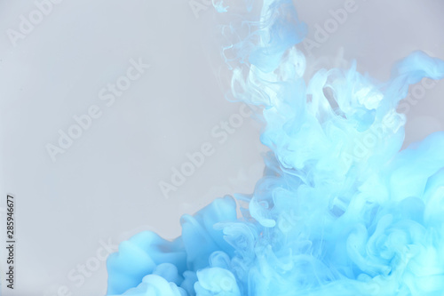 Splash of blue ink on grey background