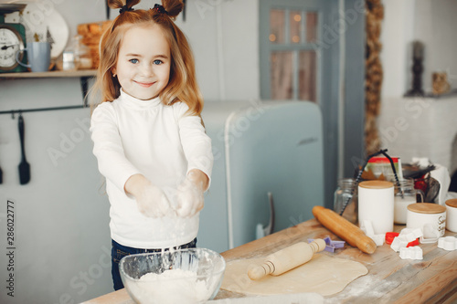 Child in a kitchen. Little girl with a dough.