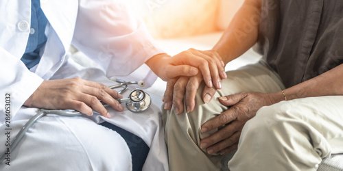 Parkinson's disease patient, Arthritis hand, gout knee pain, or mental health care with geriatric doctor consulting examining comforting elderly senior aged adult in medical exam clinic or hospital