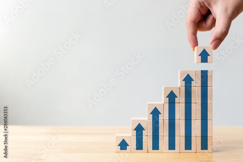 Ladder career path for business growth success process concept.Hand arranging wood block stacking as step stair with arrow up