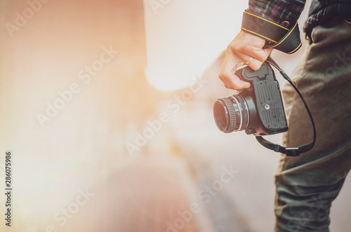 Man hipster with retro photo camera in hand, Fashion Travel Lifestyle outdoor foggy nature on city street background