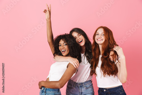 Three cute young girlfriends wearing casual outfits standing