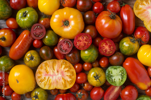 Close up of colorful tomatoes, some sliced, shot from above