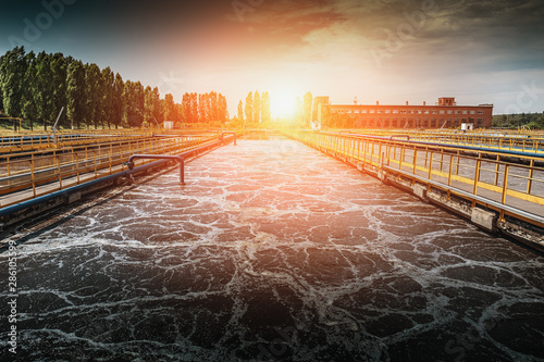 Wastewater treatment plant at sunset. Tanks for aeration and cleaning of sewage mass