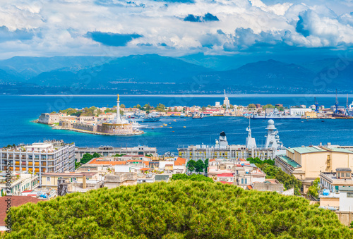 Beautiful panorama of Messina port with blue mountains in the background. It is written on the seawall in Latin "Vos Et Ipsam Civitatem Benedicimus (I Bless You And Your City), Sicily, Italy