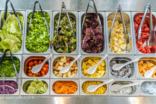 Top view of salad bar with various types of vegetables and fruits