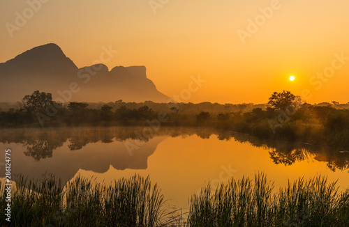 Landscape of the Hanging Lip or Hanglip mountain peak at sunrise with mist hanging above a swamp lake inside the Entabeni Safari Game Reserve, Limpopo Province, South Africa.