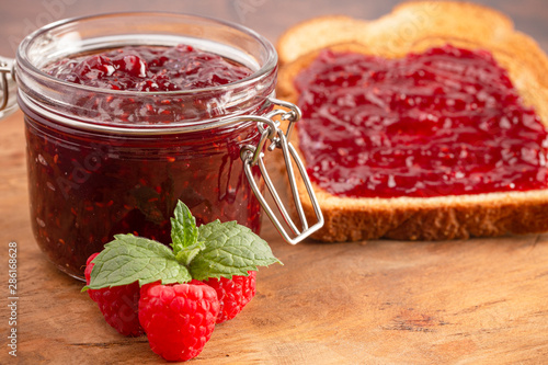 Jar of Raspberry Jam on a Rustic Wooden Table