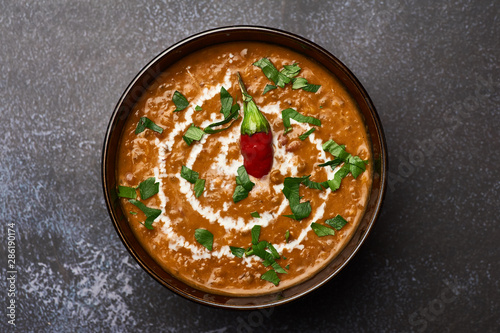 Dal Makhani at dark background. Dal Makhani - traditional indian cuisine puree dish with urad beans, red beans, butter, spices and cream.