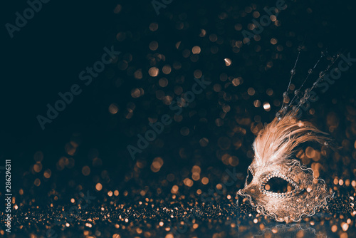 Luksusowa wenecka maska ​​na ciemnym złotym bokeh tle. Nowy rok i święto Bożego Narodzenia celebracja projekt transparent.