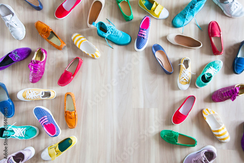 Girl chooses shoes in room on wooden background
