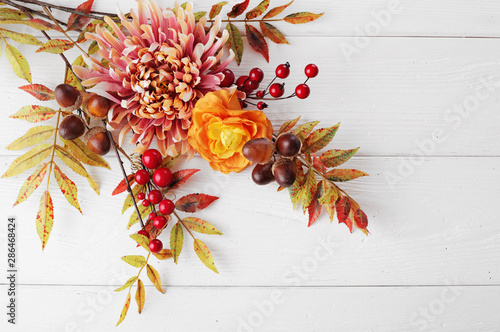 autumn leaves and fruits on wooden background