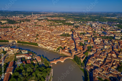 Adige river and fortified medieval castle of Castelvecchio. Aerial drone panoramic photo from city of Verona. Verona, Italy.