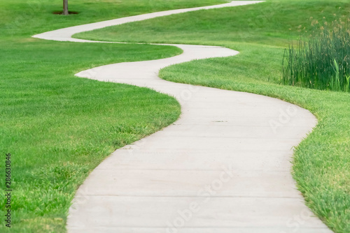 Outdoor scenery with a pathway winding through a terrain covered with grasses