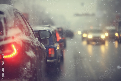 cars on winter road traffic jam city / winter weather on the city highway, the view from car in the fog and snow road