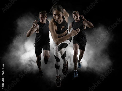 Sporty young woman and men running