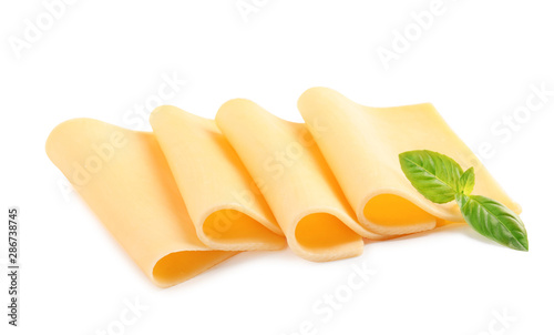 Slices of tasty cheese with basil on white background