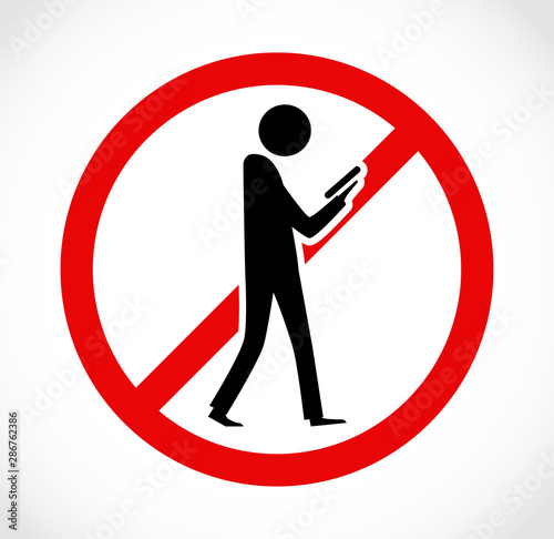 Danger on road sign concept - man with mobile phone walking through crossroad