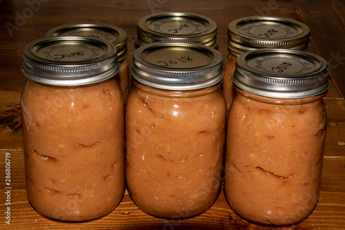 Six jars of canned apple sauce