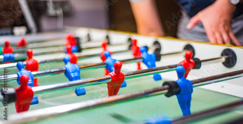 man plays table football. Detail of man's hands playing the kicker