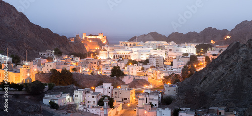 Old Muscat buildings after sunset with a view over Al Jalai Fort, middle east, Oman.