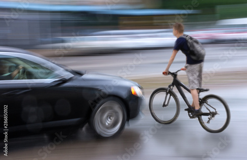 Dangerous city traffic situation with cyclist and car in the city in motion blu