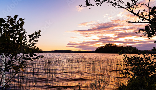 Sunset View on a lake framed by silhouetted trees from the shores of French Lake at Chippewa campground in Quetico Provincial Park, Atikokan, Ontario, Canada