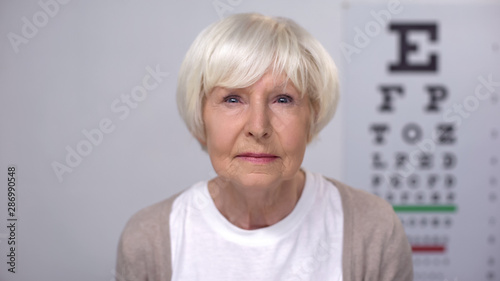 Retired female focusing vision during examination, ophthalmological check-up