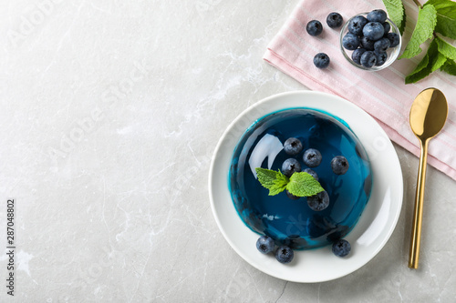 Delicious jelly with blueberries and mint on grey table, flat lay. Space for text