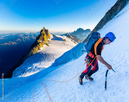 Alpinist mountaineer climbing snow ice mountain slope.